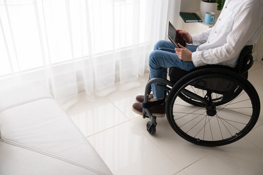 Person In Wheelchair Using Tablet At Home