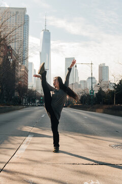 young female performing in the street on a crossroad, leg swing