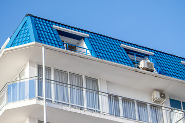 Roofs of houses with dormer windows against the sky. Urban architecture.