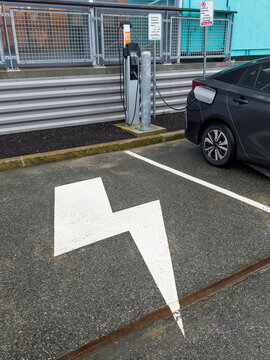 Electric car charging at designated charging station 