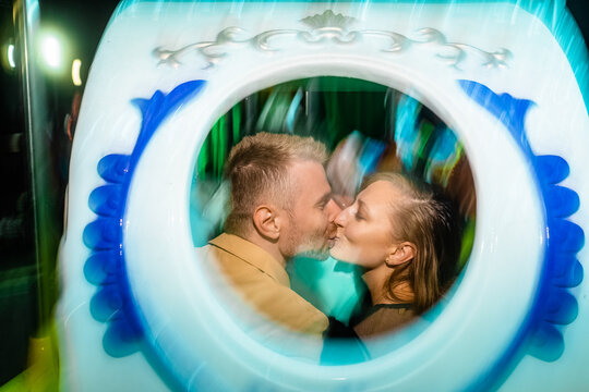 A joyful couple in love sensually kiss in the frame of the attraction