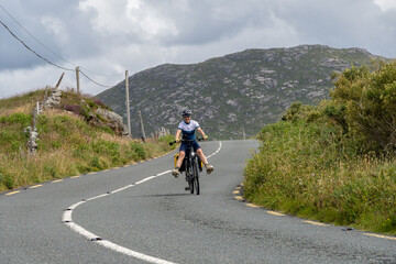 Fototapeta premium Young female traveler cyclist smiling on Connemara route