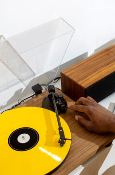 Close-up of black hands installing a vinyl record in a turntable