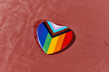 progress pride flag in a heart-shaped badge