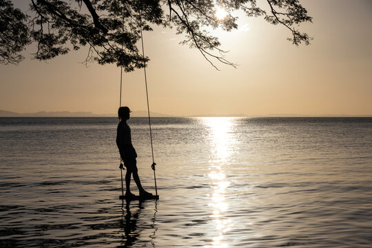 Boy on swing by lake