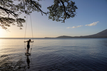 Boy on swing by lake