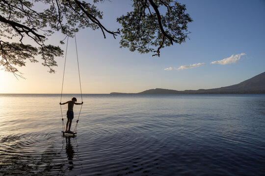 Boy on swing by lake
