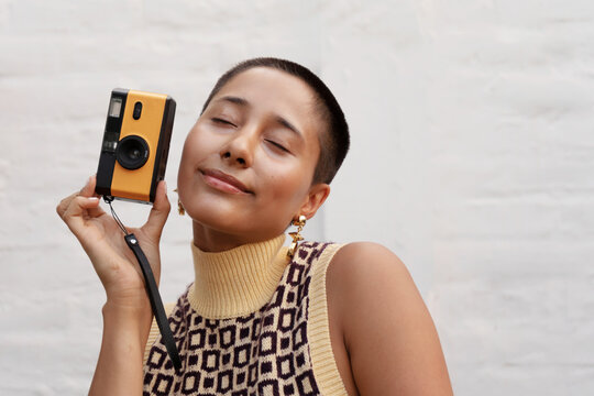 Young woman taking pictures with an analog camera