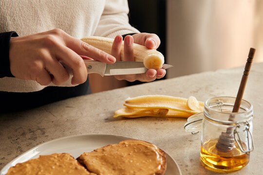Woman hands preparing banana toast snack