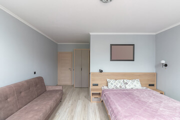 Fototapeta na wymiar Hotel room with a large double bed in light colors