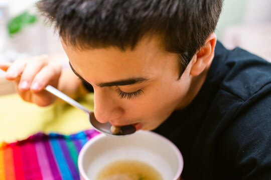 Teenager eating bone broth soup closeup