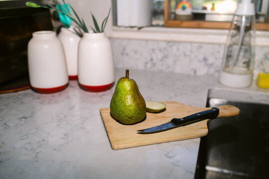 Pear on cutting table over countertop 