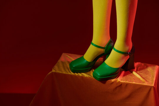 Legs of young woman in socks and shoes on color background
