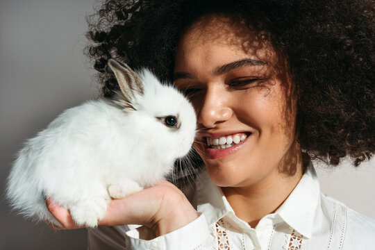 Beautiful laughing woman with rabbit in hand.