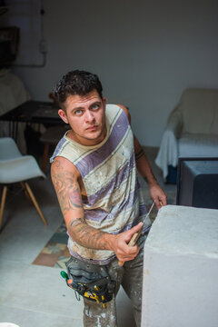 Trans man at work repairing a wall