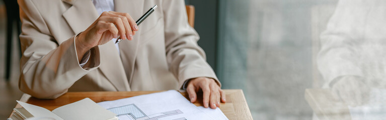 Close up of businesswoman architect working on project while sitting in cafe