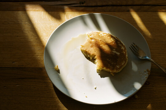 detail photo of half eaten pancake on plate on kitchen table