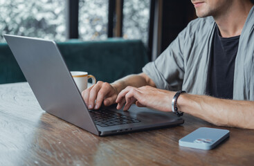 Young man using smartphone in hand, office,happy face, outdoor hipster portrait on the cafe, smile happy face, listen music on headphones, Amsterdam street, dance, player,photo concept, laptop