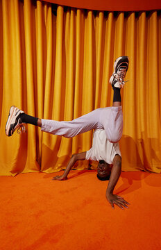 Young black guy performing handstand dance movement