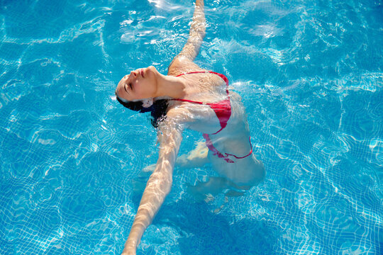 Calm woman swimming in pool water