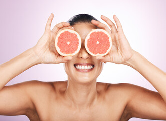 Face smile, grapefruit and skincare of woman in studio isolated on a purple background. Natural cosmetics, food and happy mature female model with fruit for vitamin c, nutrition and healthy diet.