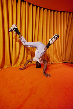 Young black guy performing handstand dance movement
