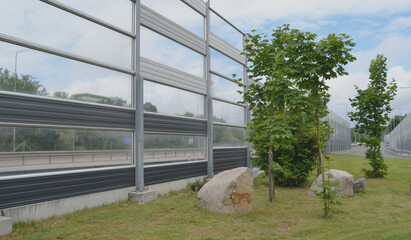 Noise-protective road barrier, which is an outdoor structure designed to protect people from noise. View of the acoustic panels from the protected living area.