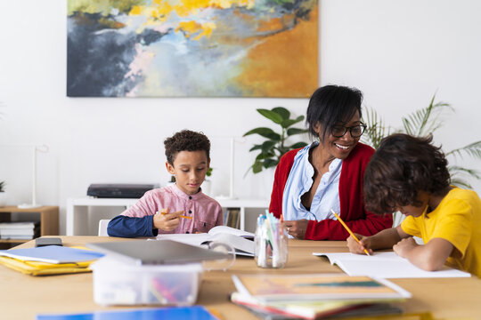 Black mother helping sons with homework