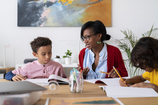 Black mother helping sons with homework