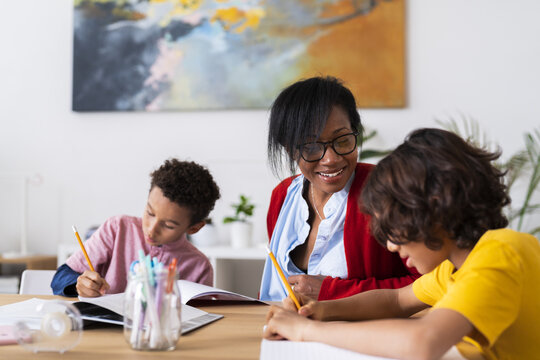 Black mother helping sons with homework