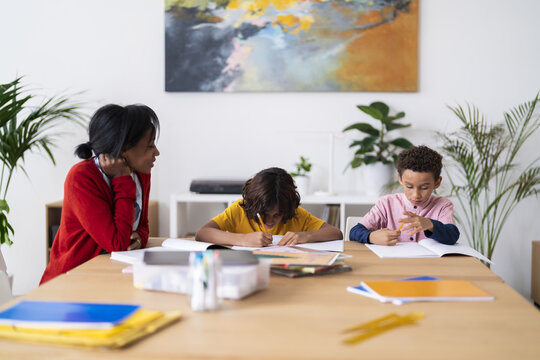 Black mother helping sons with homework