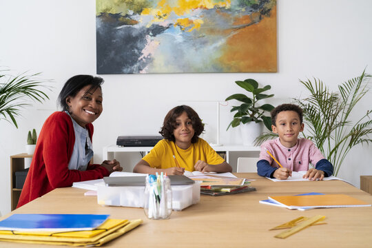 Black mother helping sons with homework