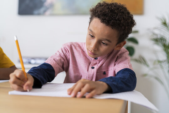 Concentrated black boy doing homework