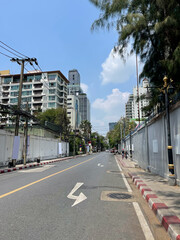 Fototapeta na wymiar Street of Bangkok city. Capital of Thailand. Empty road, fence and building. View of Krung Thep Maha Nakhon. One of the Asian largest city. Southeast Asia. กรุงเทพมหานคร Small calm street in center