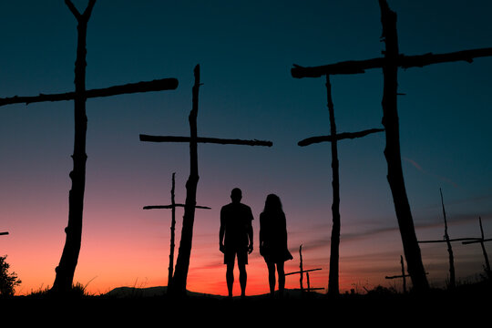 Couple silhouette at surreal wood crosses field