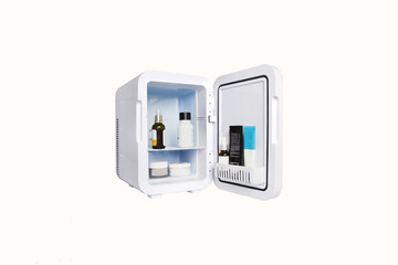 Isolated small cosmetic refrigerator on a white background,open for men and women skin care cosmetics,optimal temperature for storing creams and other moisturizing cosmetics for makeup and skin health