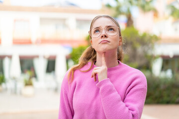 Young pretty girl at outdoors With glasses and looking up