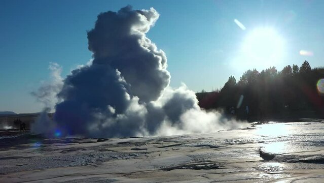 Nature. Iceland. Erupting geyser Strokkur. Strokkur is part of geothermal area. Fumaroles. Smoke over the ground. Beautiful geyser eruption on a sunny day. The most famous geyser.