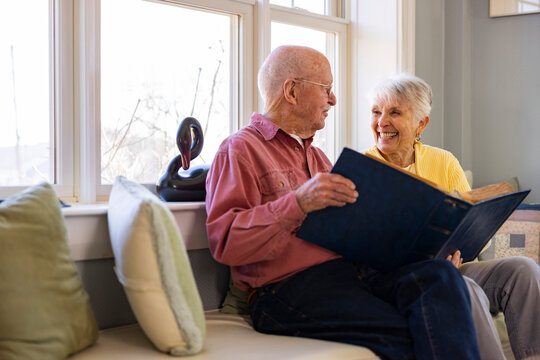 Senior Citizen couple at home Looking at photo album book 