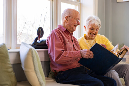 Bonding Senior Citizen couple at home Looking at photo album 