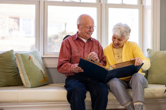 Senior Citizen couple at home Looking at photo album together 