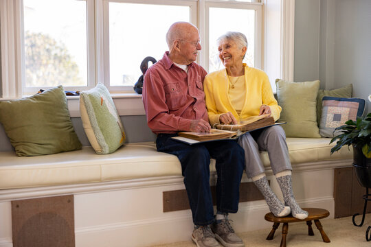 Fun and happy Senior Citizen couple at home Looking at photo album 