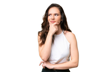 Young caucasian woman isolated over isolated background having doubts and with confuse face expression