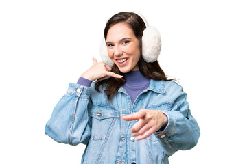 Young caucasian woman wearing winter muffs over isolated background making phone gesture and...