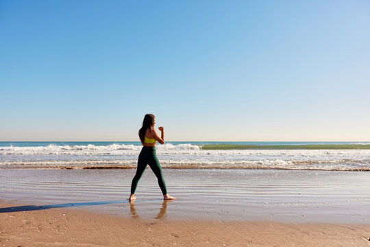 Sportswoman standing with fist defense gesture on beach