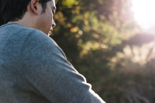 Mindful man meditiating outside on rocks.