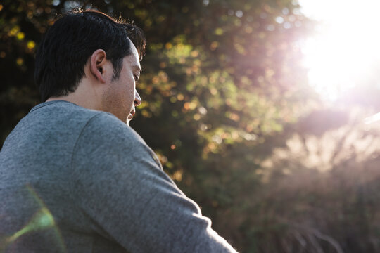 Mindful man meditiating outside on rocks.