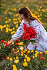 Woman field tulips sunset. Woman against sunset and wild tulip flowers, natural seasonal background. Multi-colored tulips Tulipa schrenkii in their natural habitat are listed in the Red Book.