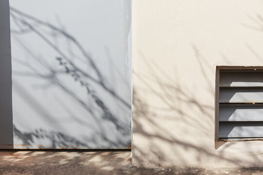 Shadows cast on the walls and doors of buildings.