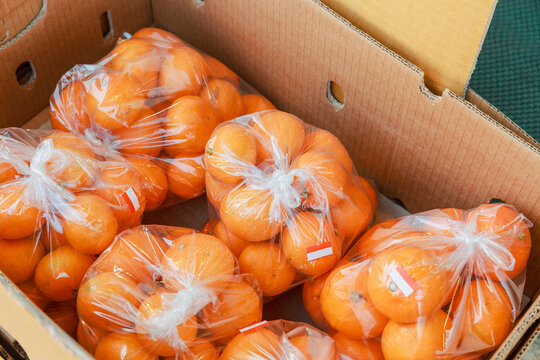 Packed orange tangerines on display outside.